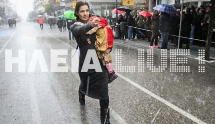 Πήρε αγκαλιά το παιδί της και... έκανε μόνη της παρέλαση στη βροχή! ΒΙΝΤΕΟ