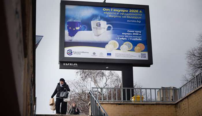 A woman passes by a billboard displaying Eurozone information campaign in Sofia, Saturday, Dec. 27, 2025. (AP Photo/Valentina Petrova)